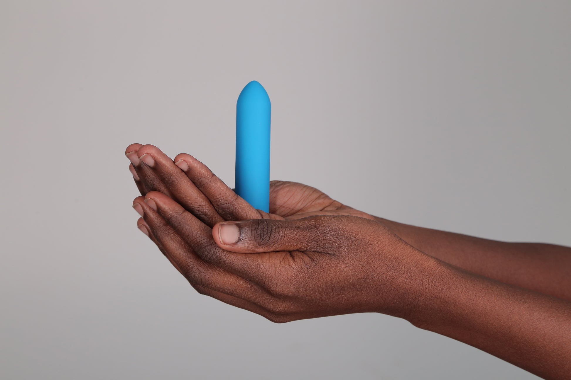 Hand holding Classic Bullet Vibrator in teal