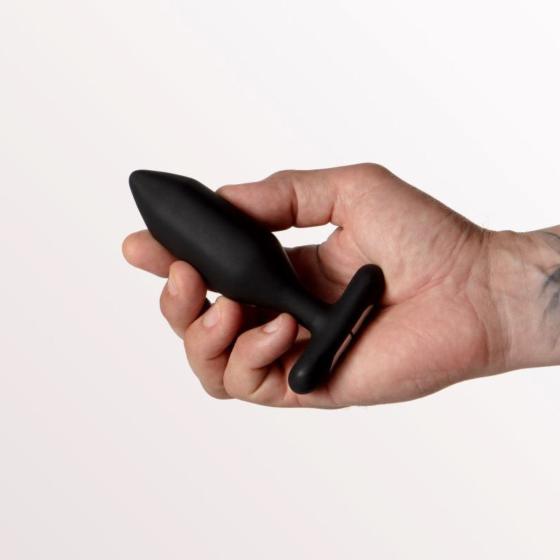 Tattooed arm holding Onyx Butt Plug by Je Joue