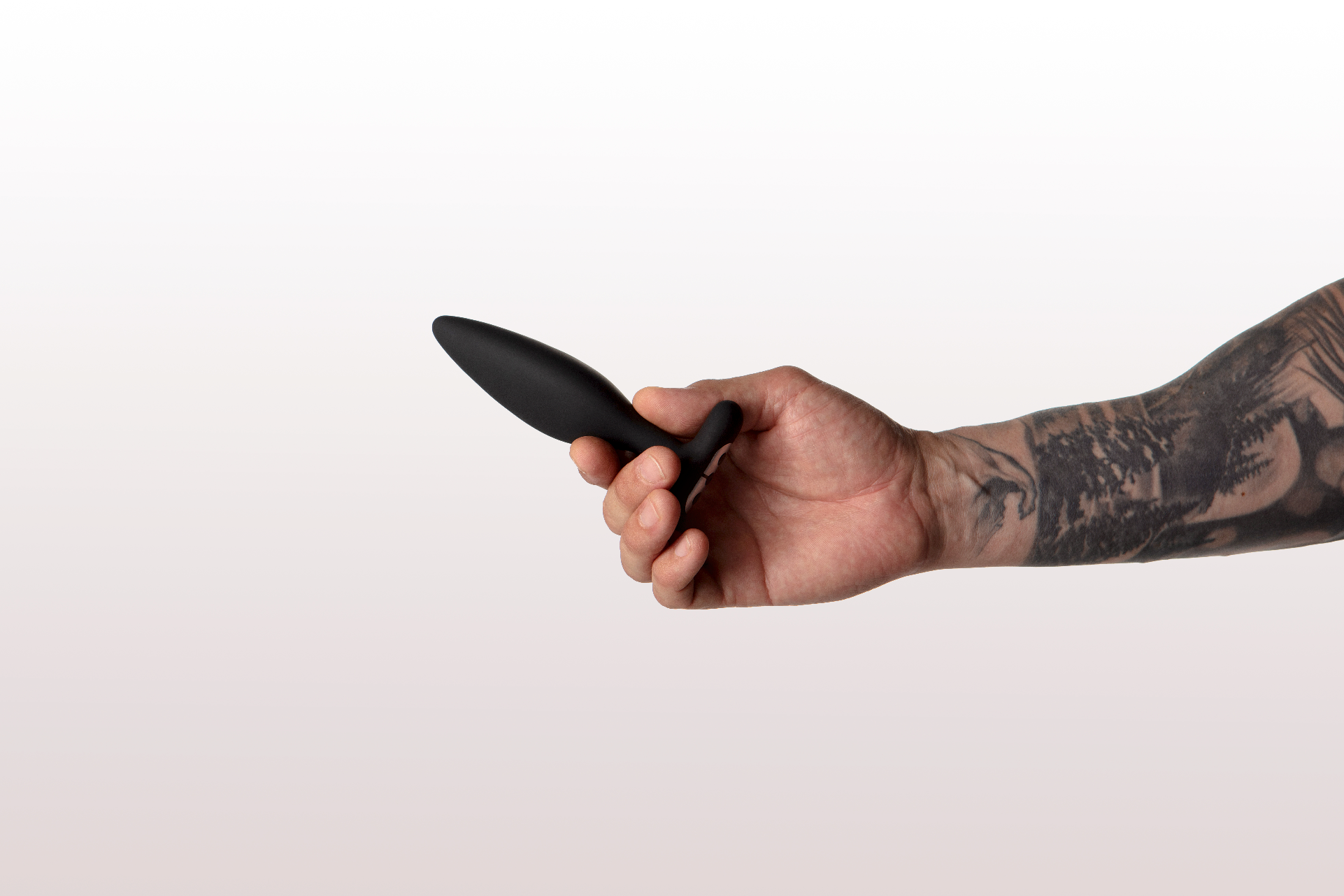 tattooed arm holding vesta butt plug