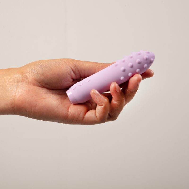 Hand holding Duet bullet vibrator in lilac
