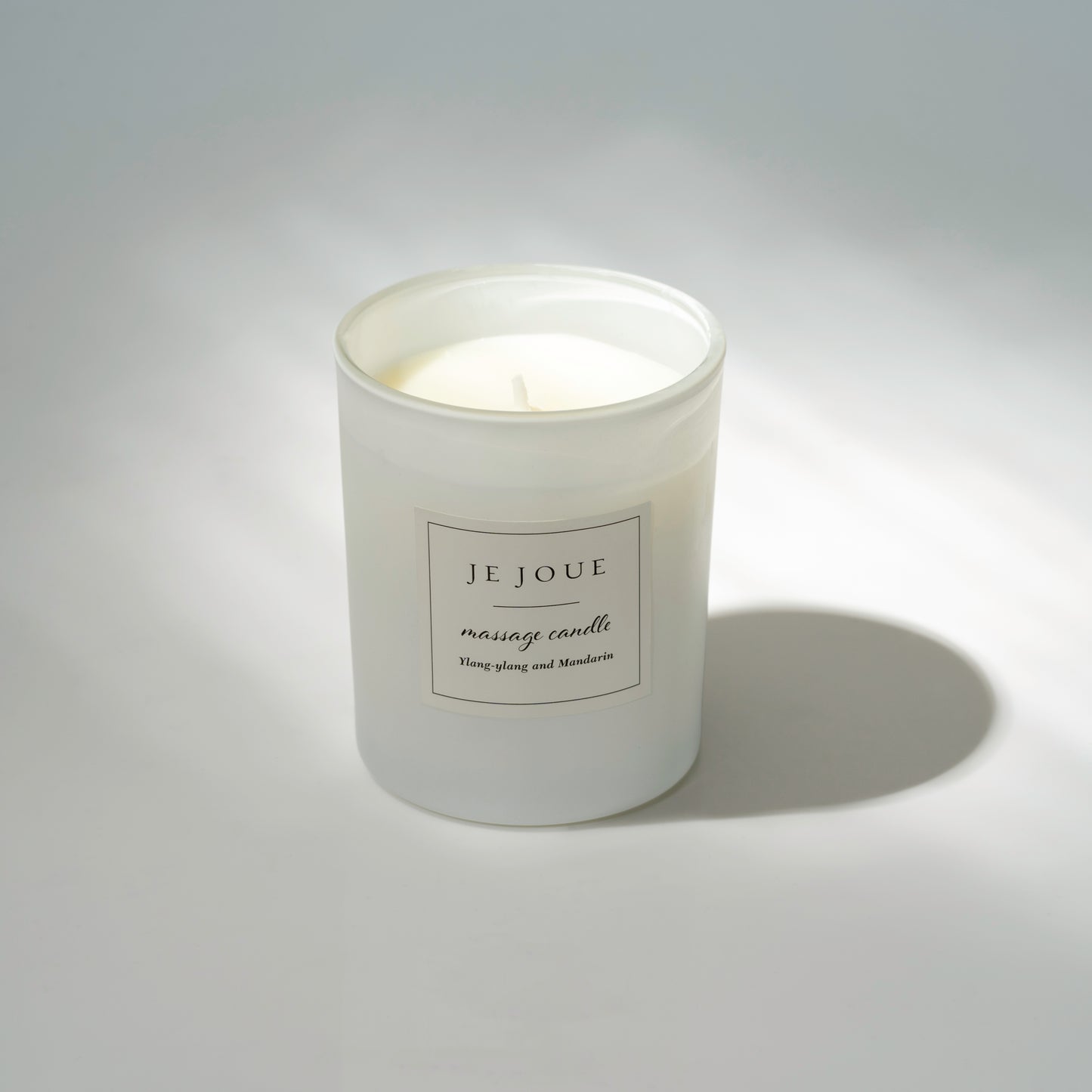 Je Joue white candle with shadow